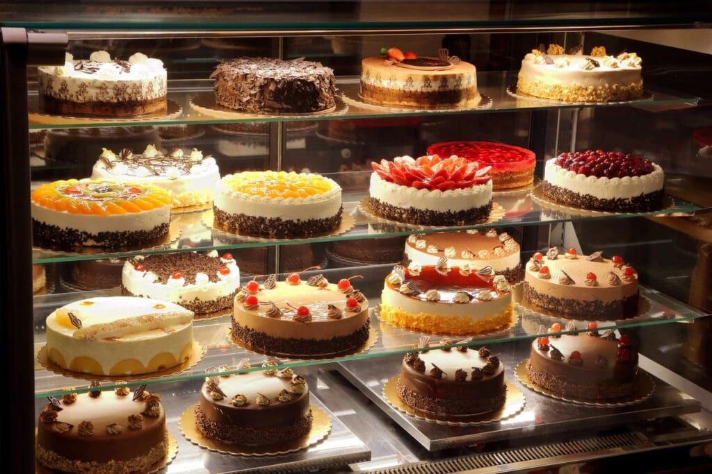 A display case filled with lots of cakes.