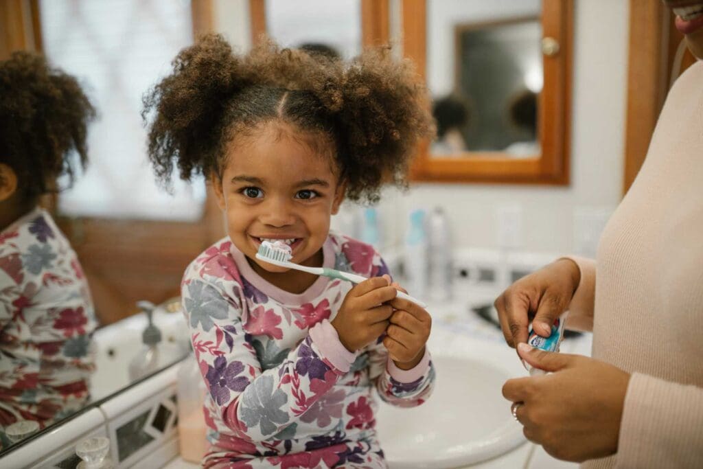 A little girl is brushing her teeth in the bathroom