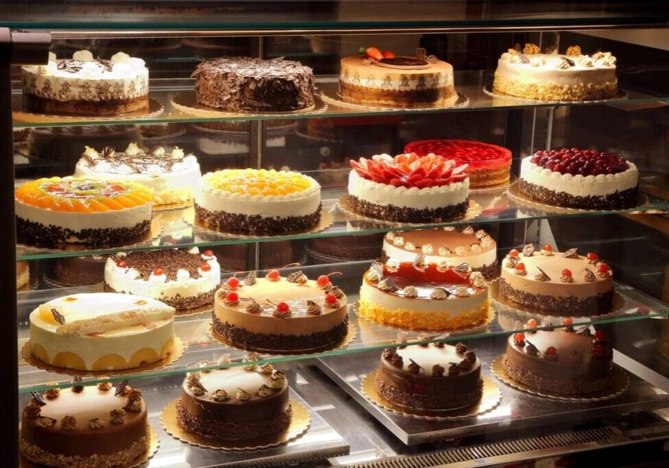 A display case filled with lots of cakes.