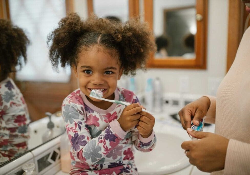 A little girl is brushing her teeth in the bathroom